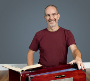 Hari-kirtana das standing at a podium with an open book